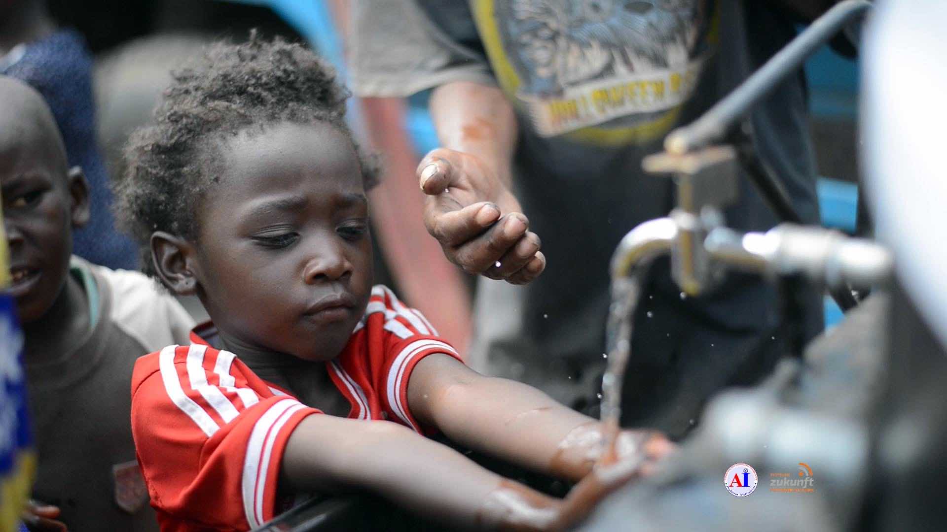 A young child could not wait to use the handsfree water stations provided by Ayiera Initiative